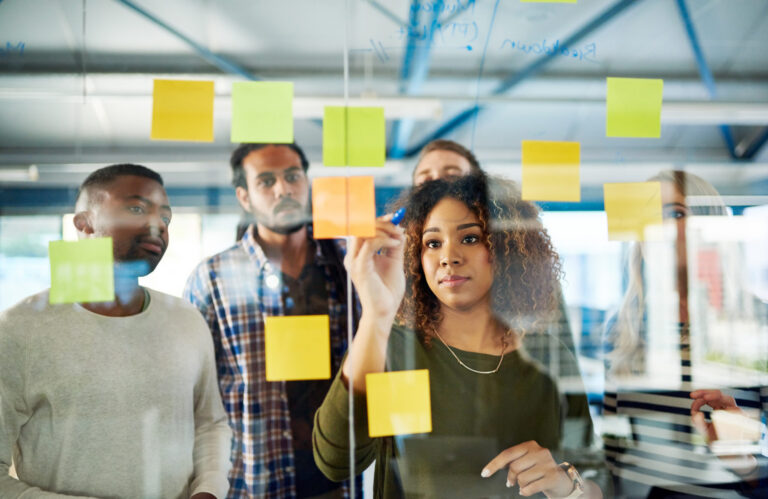 Diverse business people strategizing with sticky notes