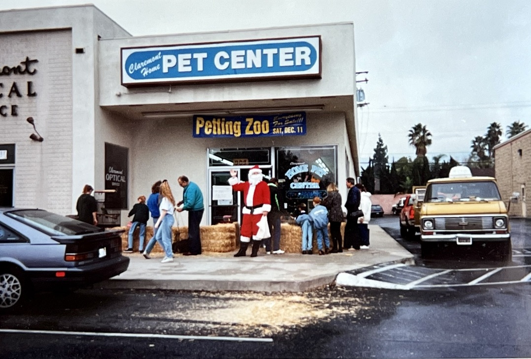 The Claremont Home Pet Center storefront on Route 66, with a Santa, hay bales, and a Petting Zoo banner during a holiday event.